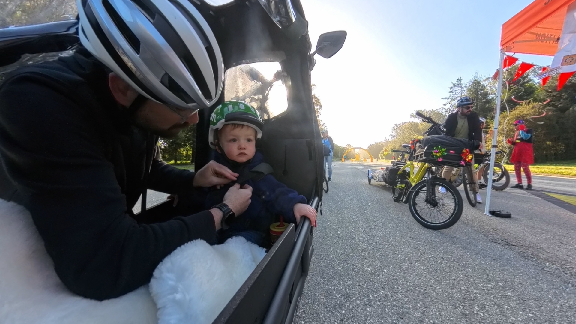 Owen riding in the cargo bike through the park